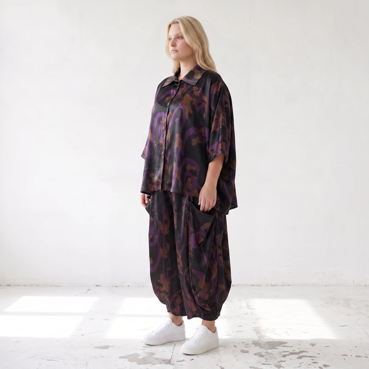 Ballonhose aus Satin in Schwarz/Violett/Braun mit abstraktem Printmuster und Elastikbund