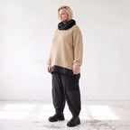 Beiger Strickpullover mit Rollkragen und seitlichen Schlitzen vorne kurz hinten lang
