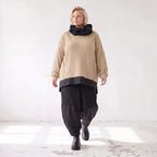 Beiger Strickpullover mit Rollkragen und seitlichen Schlitzen vorne kurz hinten lang
