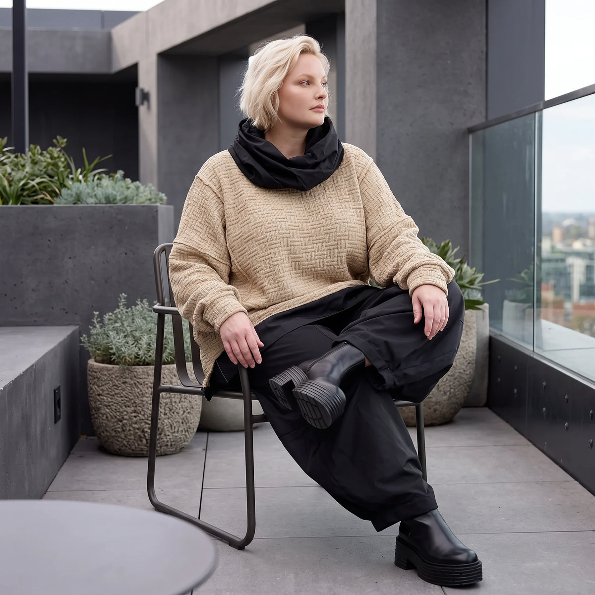 Beiger Strickpullover mit Rollkragen und seitlichen Schlitzen vorne kurz hinten lang