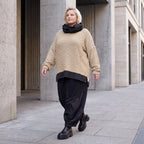 Beiger Strickpullover mit Rollkragen und seitlichen Schlitzen vorne kurz hinten lang