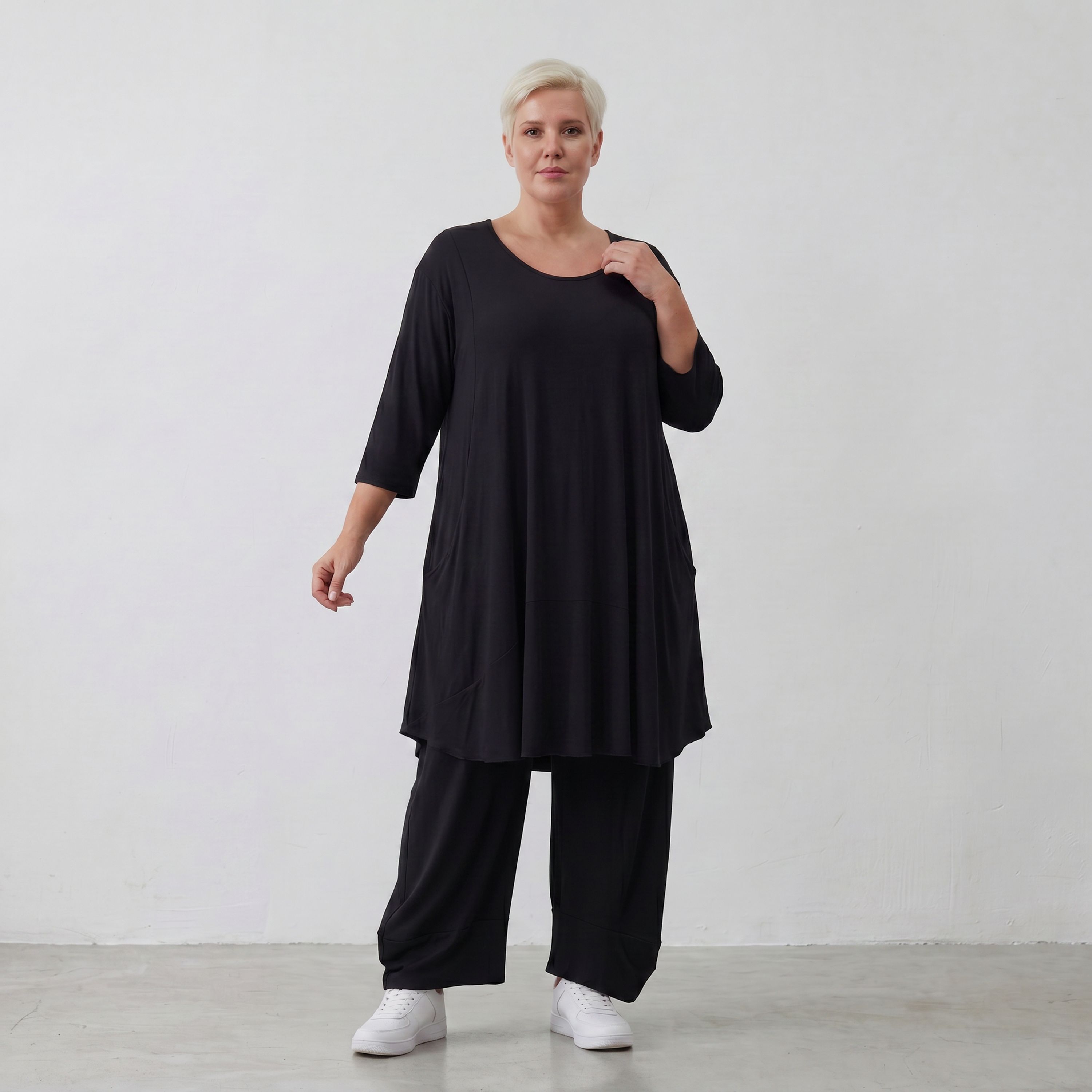 Fließendes Glockenshirt in tiefem Schwarz mit 3/4-Arm Rundhalsausschnitt und Nahttaschen