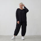 Fließendes Shirt aus schwarzem Jersey mit femininer Silhouette und leicht zipfeligem Saum