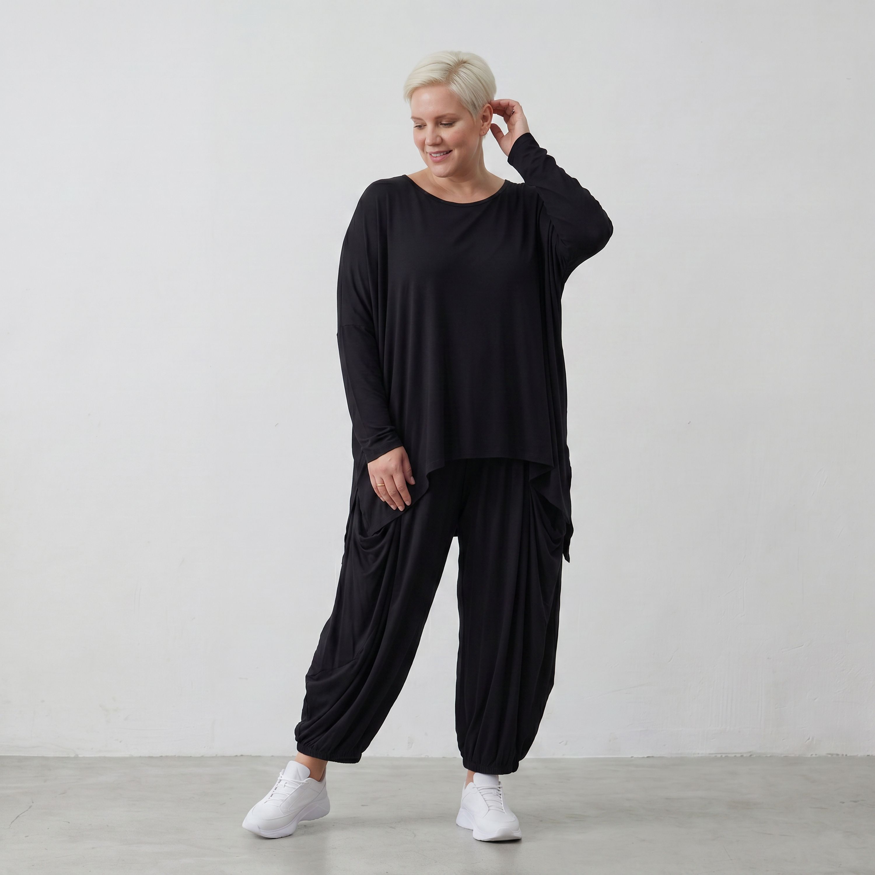 Fließendes Shirt aus schwarzem Jersey mit femininer Silhouette und leicht zipfeligem Saum